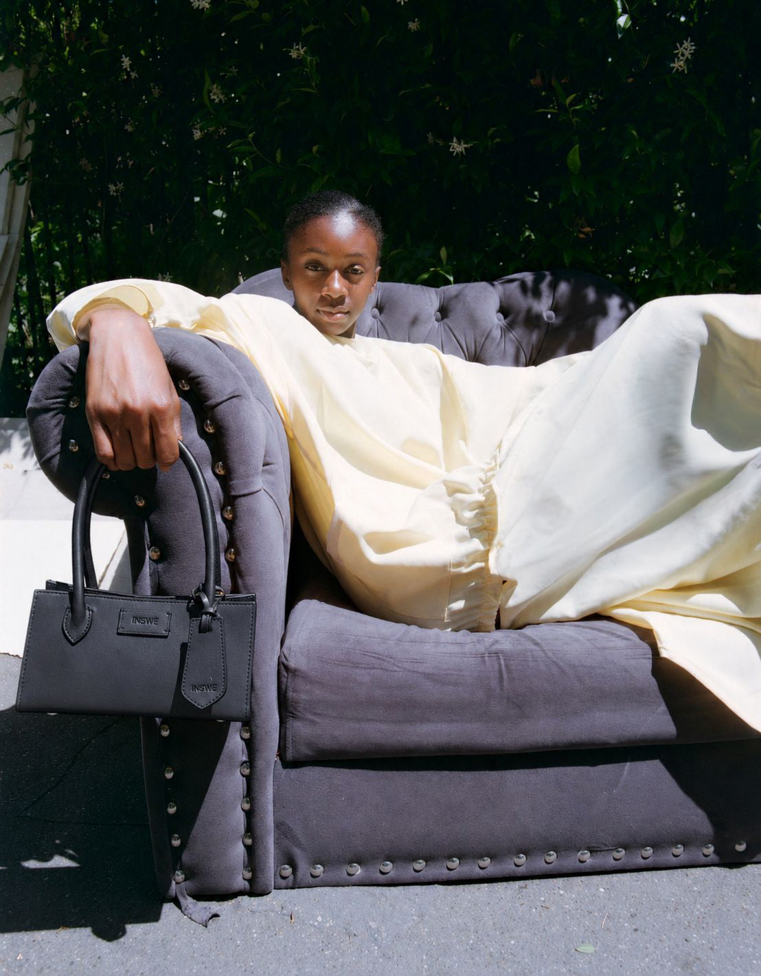 A model holding a black INSWE CESARINE leather handbag with a visible INSWE logo.